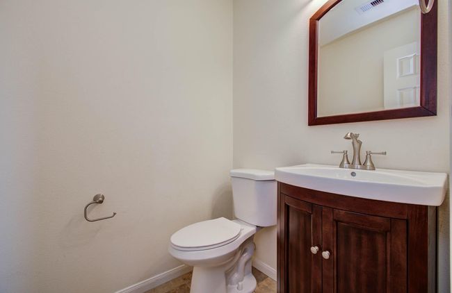The half bath is tucked in the hallway between the family room and primary bedroom. | Image 19