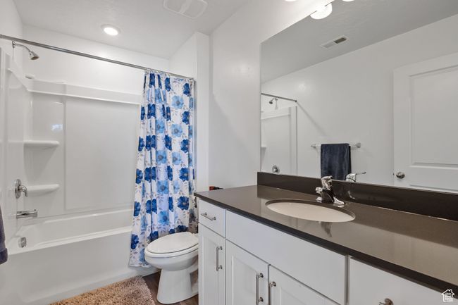 Bathroom featuring wood finished floors, visible vents, toilet, vanity, and shower / bath combo | Image 10