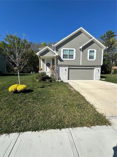 Bi-level home with a garage and a front yard | Image 1