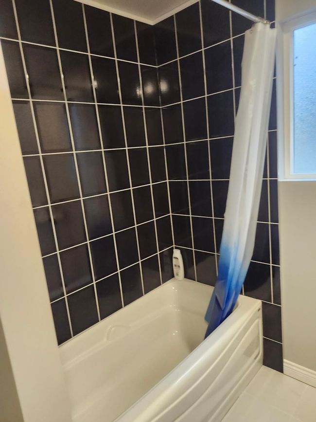 Full bath with shower / bath combo, healthy amount of natural light, and tile walls | Image 8