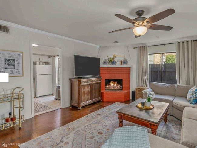 Living area featuring wood finished floors, visible vents, ornamental molding, and ceiling fan | Image 6