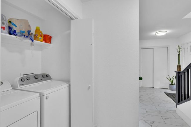 Laundry area featuring washing machine and dryer and light marble finish floors | Image 16