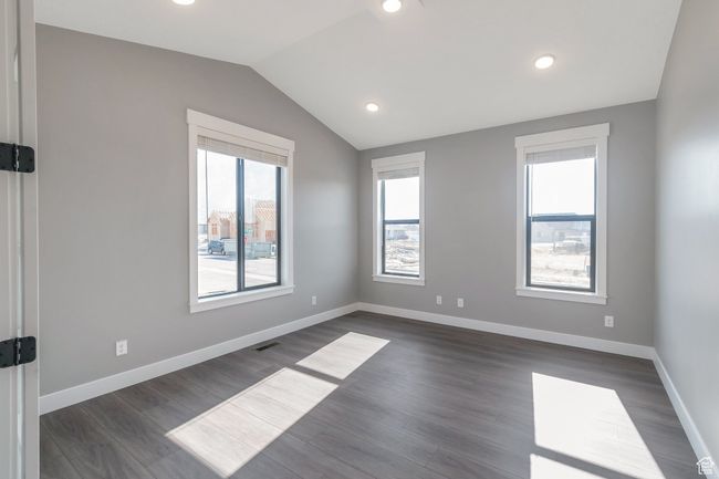 Empty room featuring lofted ceiling, dark wood finished floors, and recessed lighting | Image 8