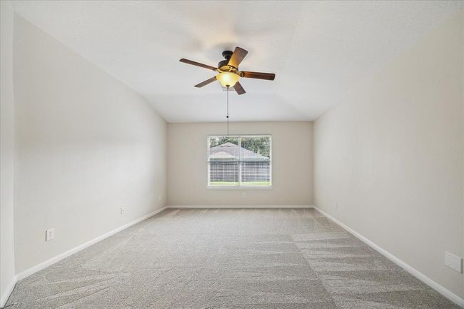 Retreat to your serene sanctuary! The spacious primary bedroom offers a peaceful escape with soft natural light, plush carpeting, and plenty of room for a king-sized bed and sitting area. Whether it’s early morning coffee or winding down at night, this space invites rest and relaxation. | Image 14