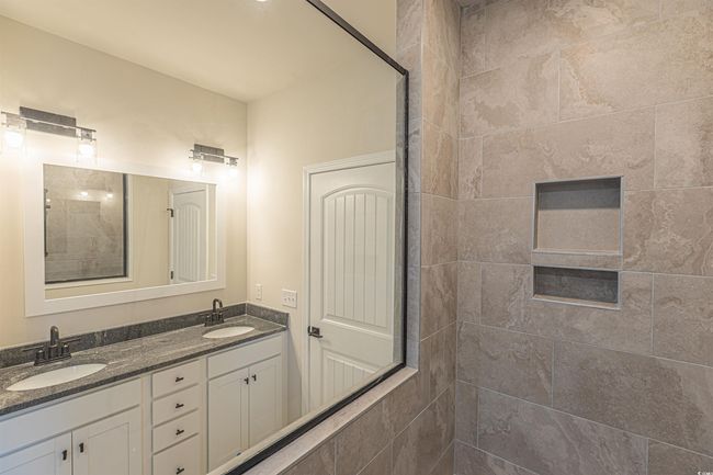 Full bathroom featuring a sink, double vanity, and a tile shower | Image 17
