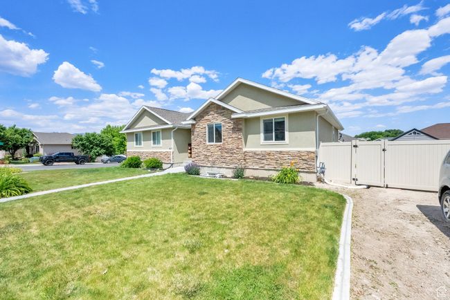 View of front of home with stone siding, a gate, and stucco siding | Image 30