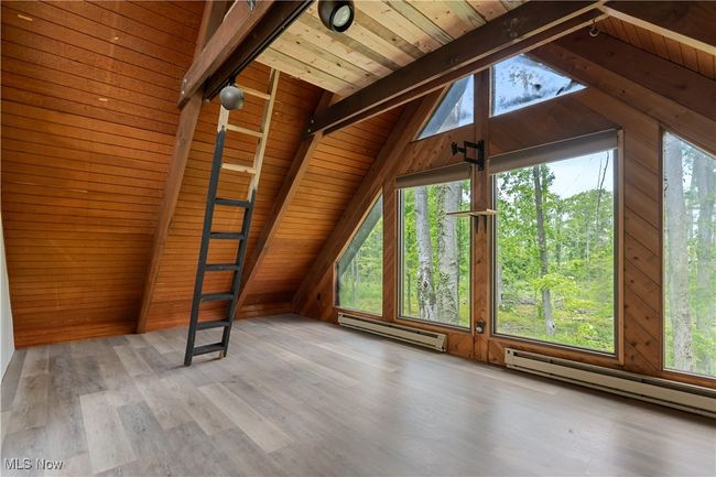 Bonus room featuring baseboard heating, wooden ceiling, wooden walls, and wood finished floors | Image 19