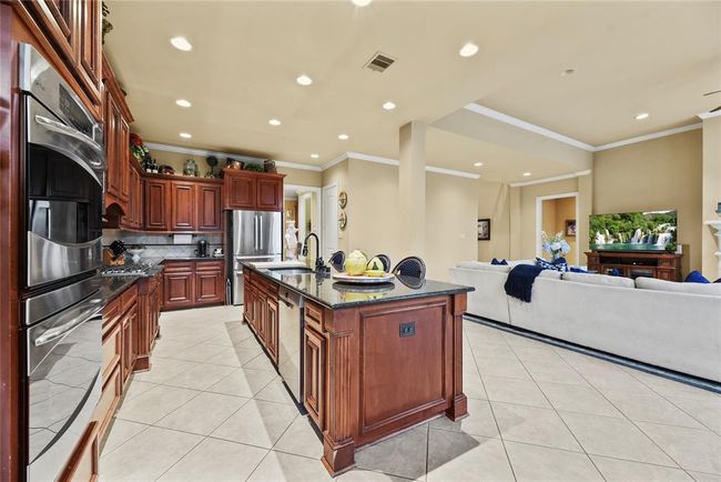 Open concept kitchen allows for guests to relax or watch the big game in the Family Room while you prepare a delicious spread of food and treats. | Image 9
