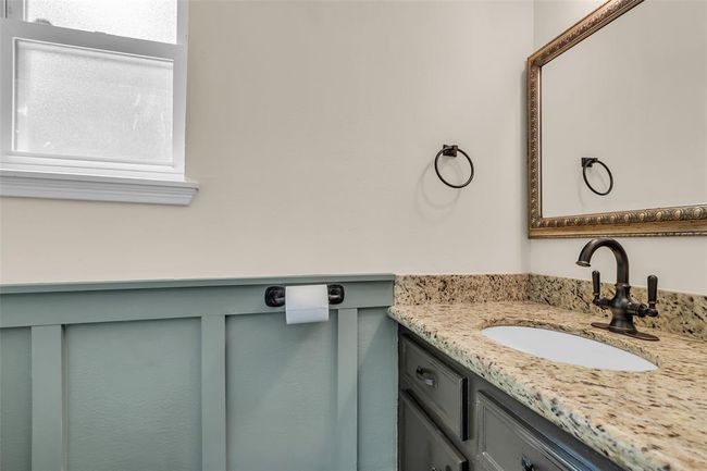 Updated half bath with granite tops and wainscoting accent. | Image 17