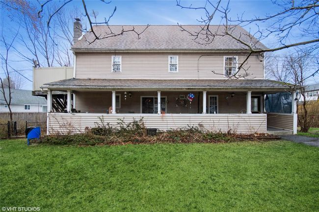 View of front of property with fence, a chimney, a front yard, roof with shingles, and covered porch | Image 21