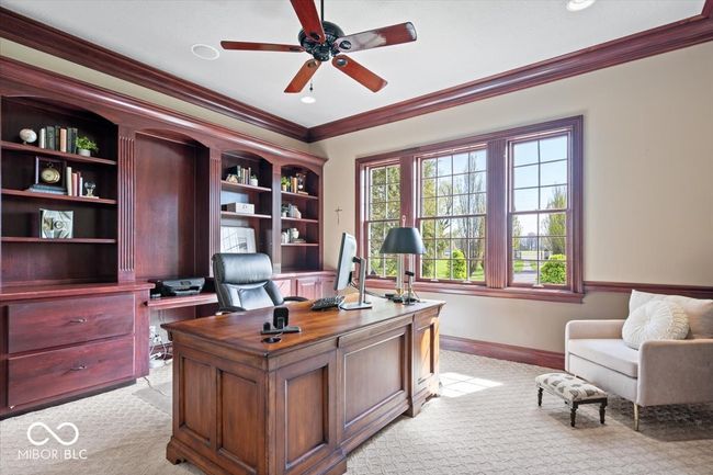 Main level home office with mahogany cabinetry overlooks the front of the property. | Image 44