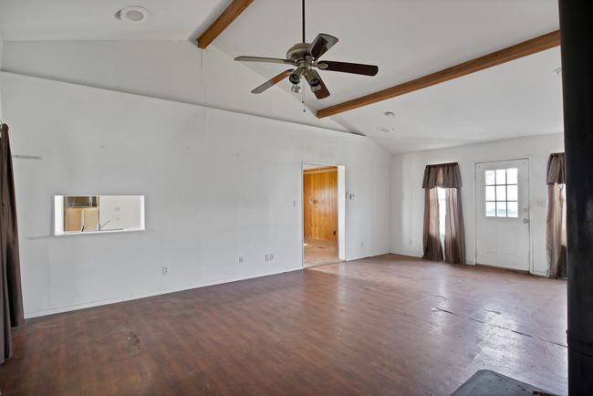 Empty room featuring a ceiling fan and wood finished floors | Image 7
