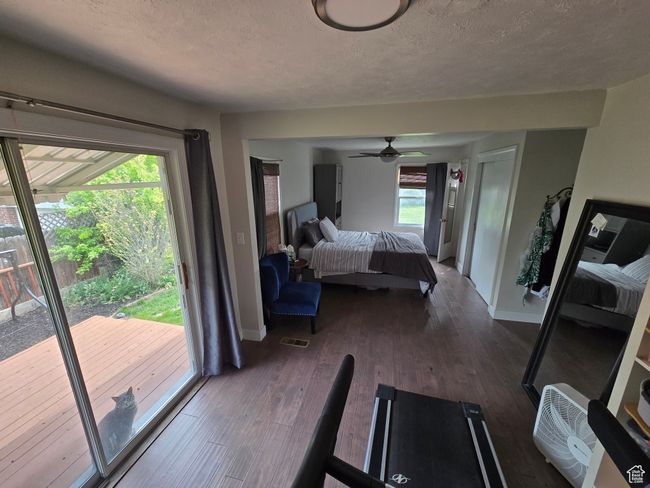 Bedroom featuring wood finished floors, access to exterior, baseboards, visible vents, and a textured ceiling | Image 24
