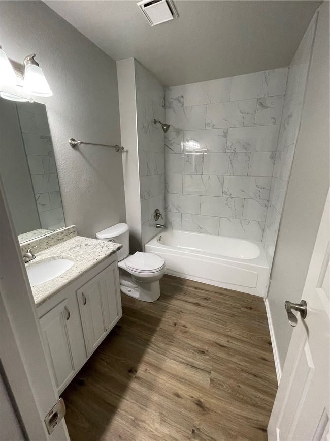 Bathroom with wood finished floors, vanity, and shower / washtub combination | Image 21