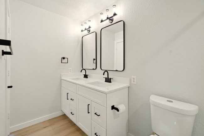 Primary bath with dual vanities, shaker cabinetry and vinyl plank flooring | Image 13