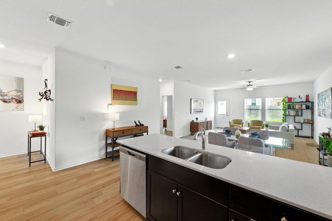 Kitchen featuring dishwasher, a sink, open floor plan, light countertops, and a ceiling fan | Image 13