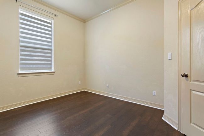 Empty room featuring baseboards, crown molding, and dark wood-style floors | Image 23