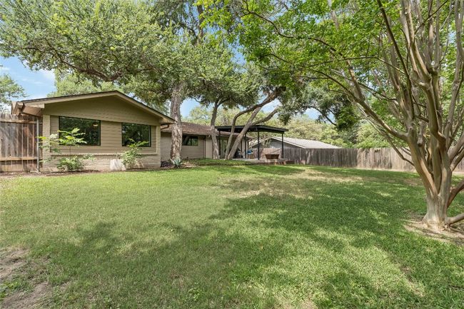 Soaring mature shade trees tower over the backyard, which is also updated with professional landscaped steel edged garden/flower boxes, ready for your spring plantings. | Image 34