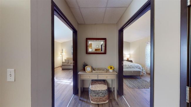 Hall with wood finished floors and a drop ceiling | Image 13