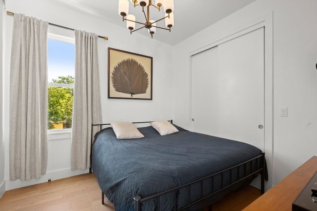 Bedroom featuring a chandelier, light wood-type flooring, and a closet | Image 25