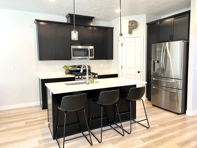 Dark cabinets, quartz counter tops, pantry and stainless steel appliances. | Image 5