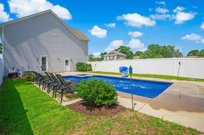 View of swimming pool featuring a jacuzzi and a patio area | Image 6