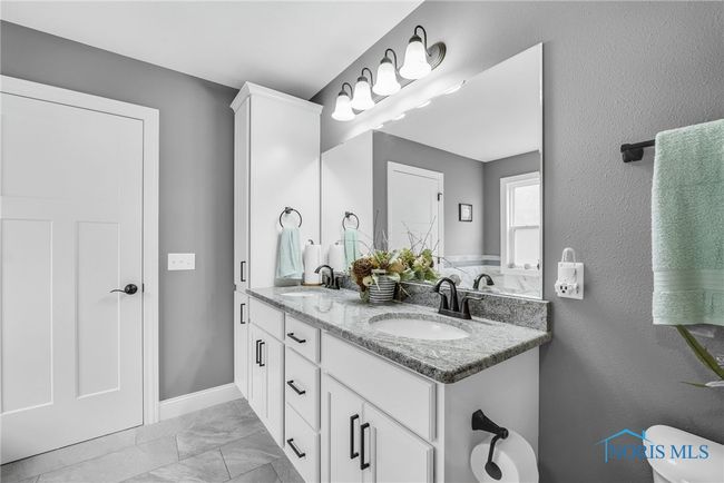 Primary bathroom has granite countertops, dual sinks and a storage tower. | Image 12