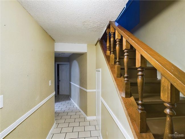 Staircase featuring light tile floors and a textured ceiling | Image 7