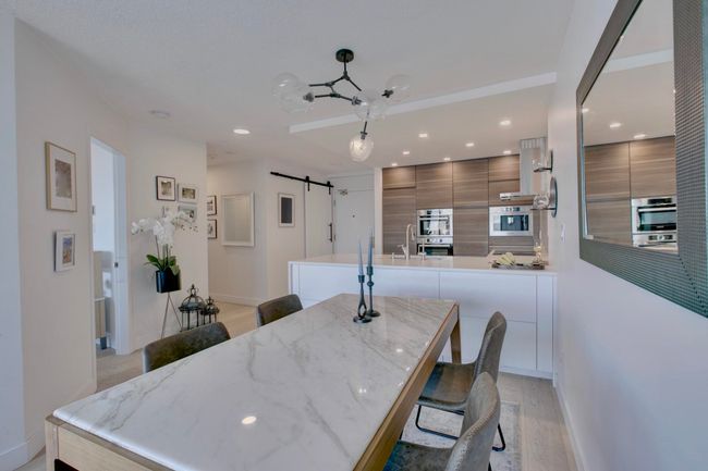 Dining room featuring light wood-style floors, a barn door, and recessed lighting | Image 6