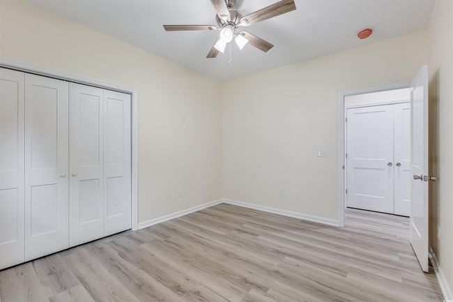 Unfurnished bedroom featuring light wood-style flooring, baseboards, a closet, and a ceiling fan | Image 14