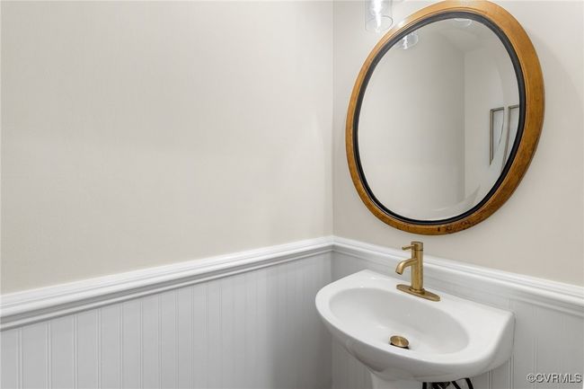Bathroom with a wainscoted wall, sink and commode. | Image 23