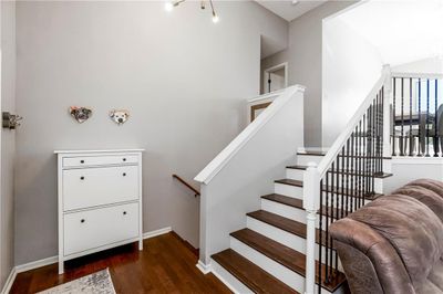 Staircase with wood-type flooring and an inviting chandelier | Image 3