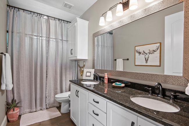 Bathroom with double vanity and a shower with curtain | Image 22