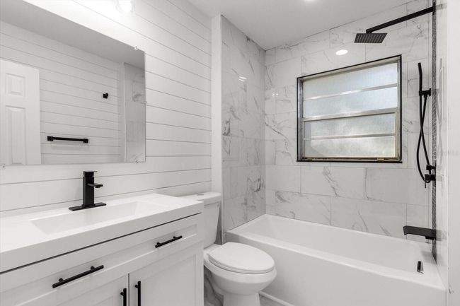 Renovated Full Bath... Tub/Shower Combo w/ NEW Tile Surround & Accent Stripe, NEW Vanity, NEW Center Flush Toilet & NEW Plumbing Fixtures including Rainfall Shower Head, Handheld Shower Wand & Waterfall Tub Spout | Image 4