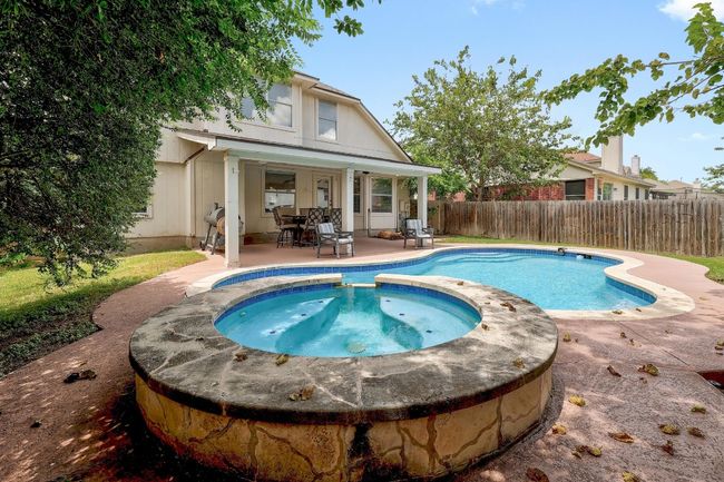 View of pool featuring a patio area, a fenced backyard, and a pool with connected hot tub | Image 29