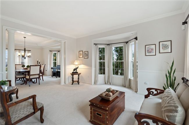Plush carpet and bay window are featured in the spacious living room. | Image 4