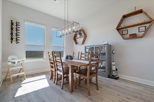 Dining area with a chandelier, light wood-type flooring, and baseboards | Image 13