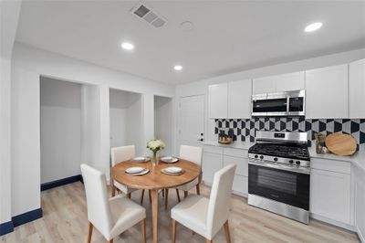 Kitchen with stainless steel appliances, backsplash, white cabinets, and light hardwood / wood-style floors | Image 3