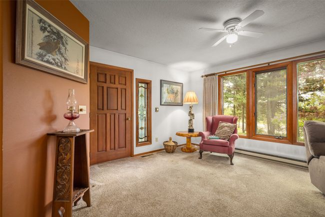 Living area with carpet floors, ceiling fan, baseboards, and a textured ceiling | Image 17