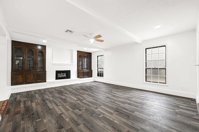 The living room features a fireplace, built in cabinetry and tons of natural light. | Image 12