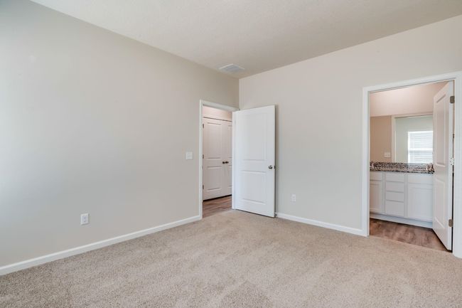 Unfurnished bedroom with light carpet and ensuite bathroom | Image 13