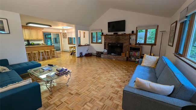 Living area featuring vaulted ceiling, fireplace, wood floors | Image 8