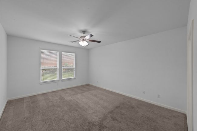 Carpeted spare room featuring ceiling fan and baseboards | Image 24