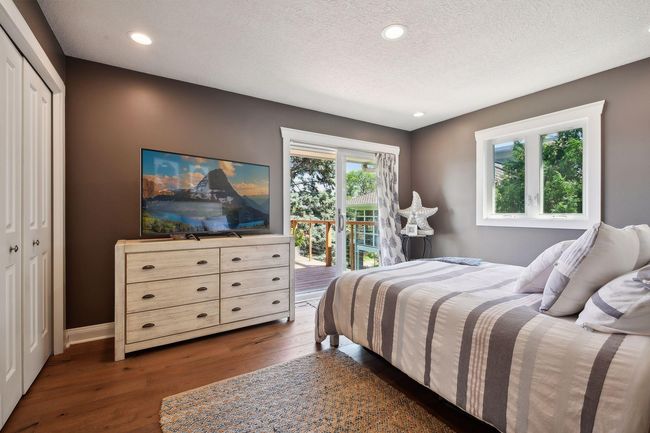 The primary bedroom also walks out to the lakeside deck and offers serene views. | Image 16