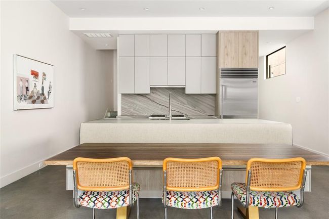 The kitchen strikes a perfect balance of modern form and practical function, featuring flat-panel Madeval cabinetry, dramatic backsplash and countertops, and top-of-the-line Subz-zero/Wolf appliances. | Image 13