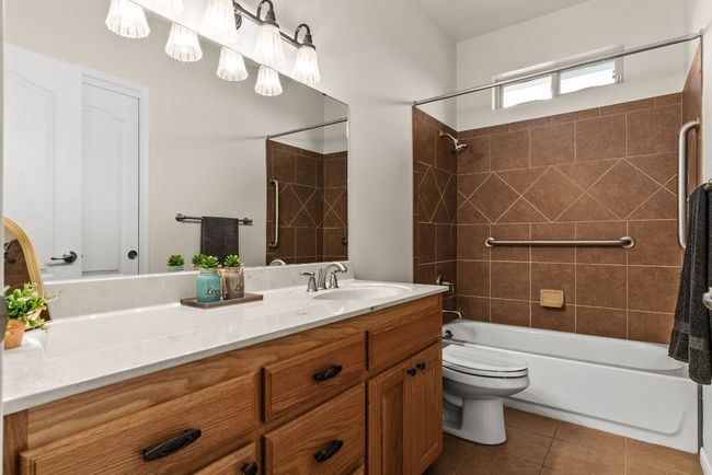 Full bath with tile patterned flooring, vanity, bathtub / shower combination, and toilet | Image 30