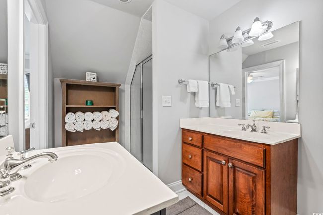 Ensuite bathroom with a shower with door, vanity, and a ceiling fan | Image 20