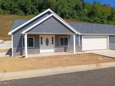 View of front of house featuring a porch and a garage | Image 1