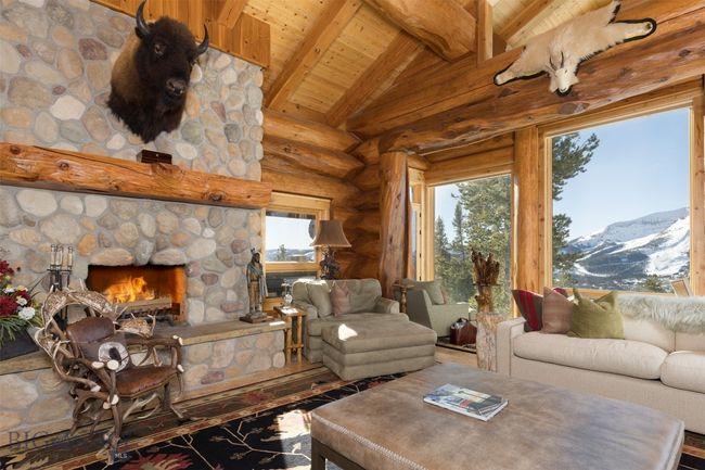 Main level great room with stunning mountain views, vaulted ceiling with beams, stone fireplace, with exit door to extensive outdoor deck. | Image 39