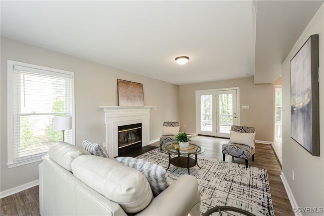 Living room with wood finished floors, plenty of natural light, baseboards, and a glass covered fireplace | Image 26